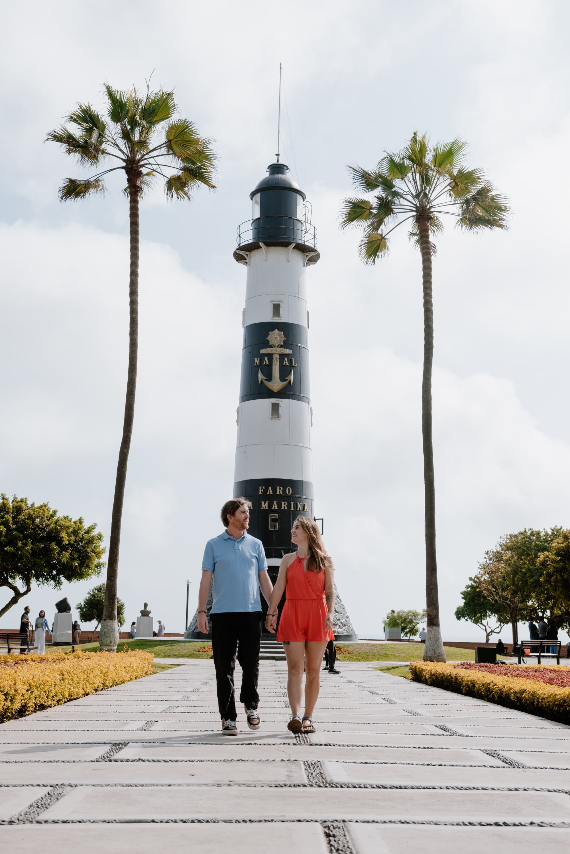 Couple posing in front of a lighthouse.