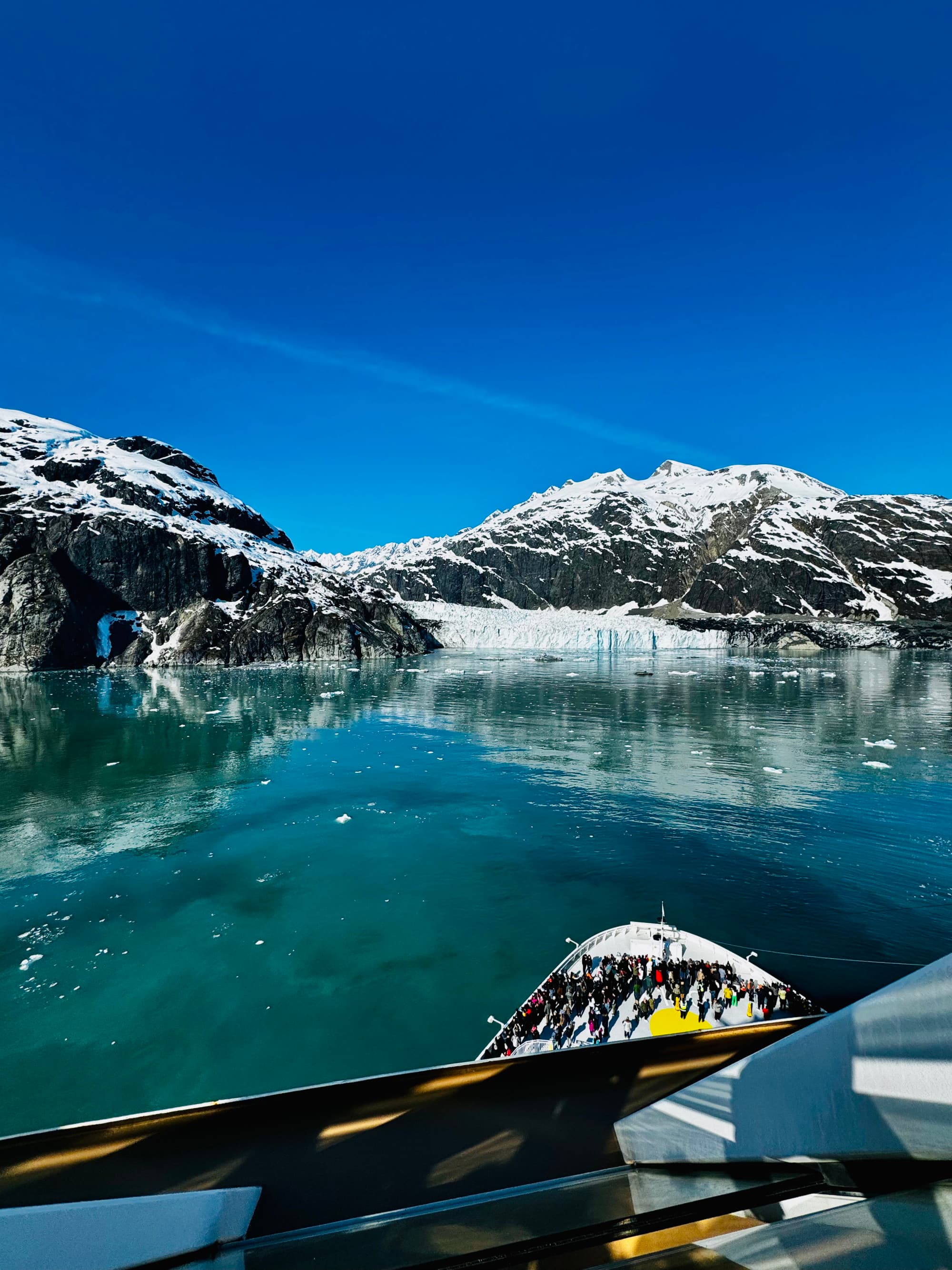 Front deck of a kayak with glaciers in the background.