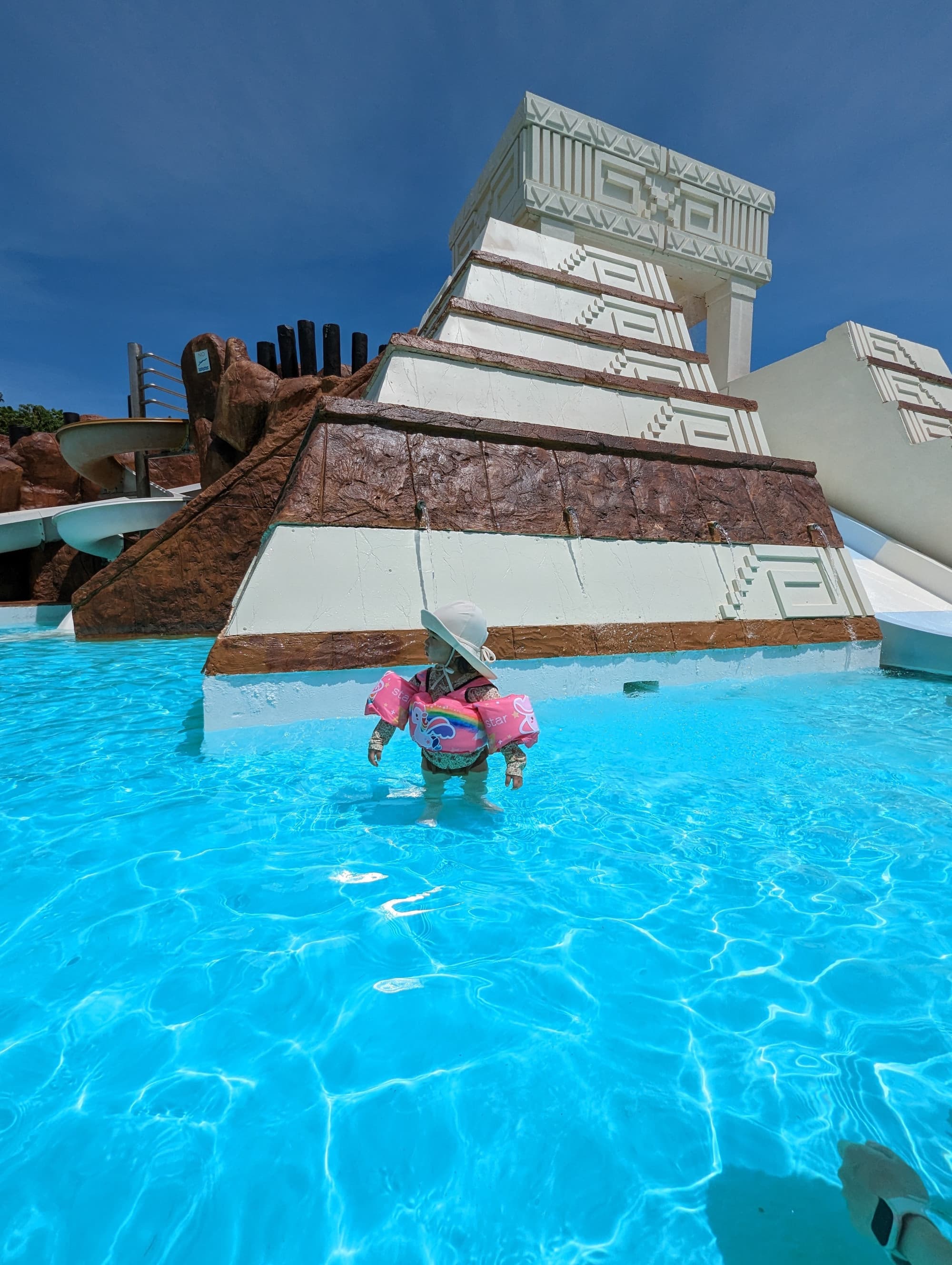 A kid with water wings in the pool.