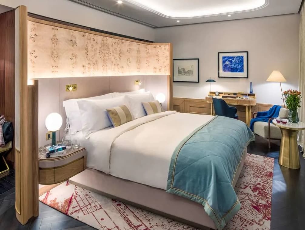 luxury hotel rooms with a large bed and a desk and soft lighting