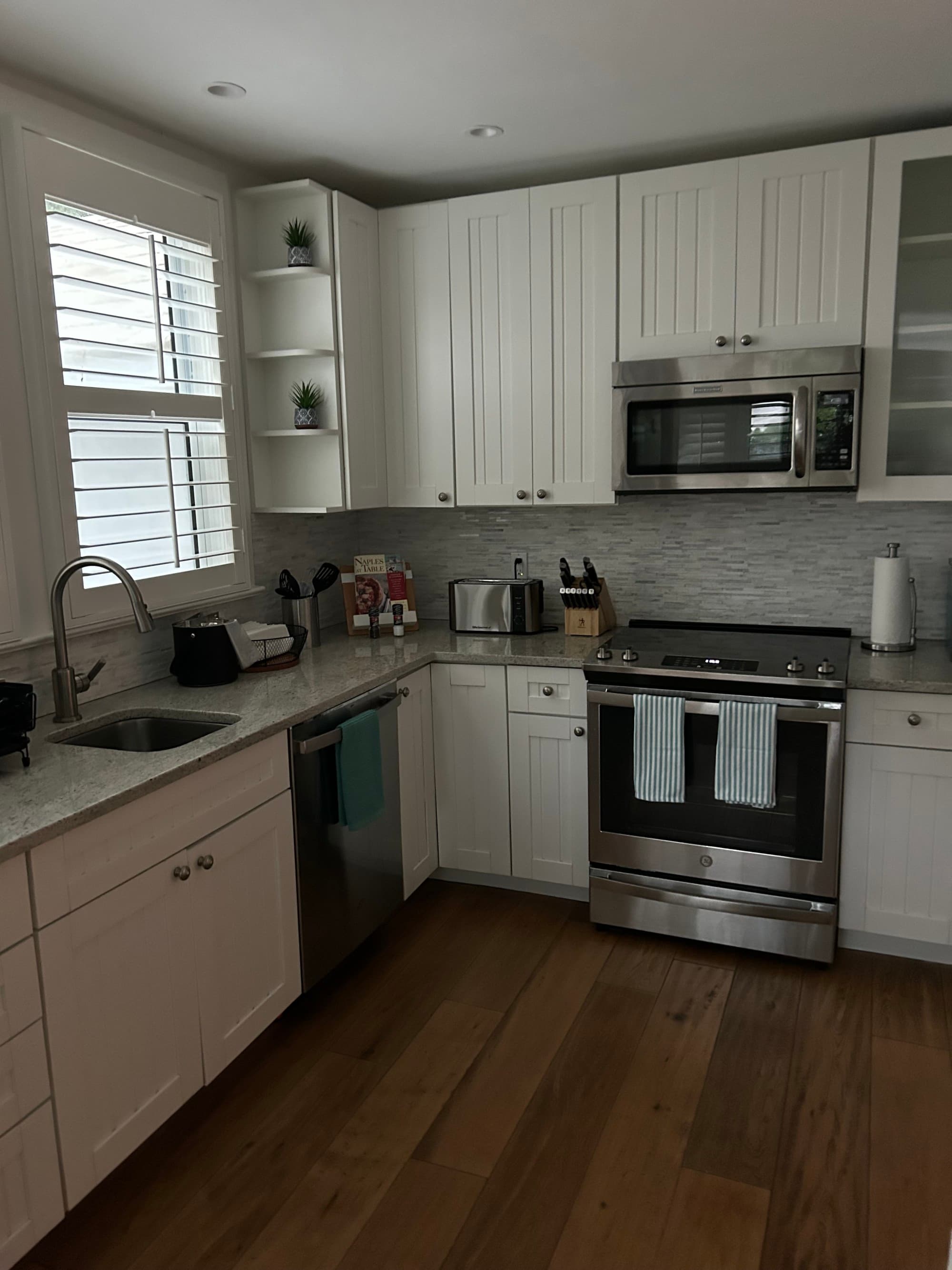 Cottage kitchen with wooden floors and a silver cooking range.