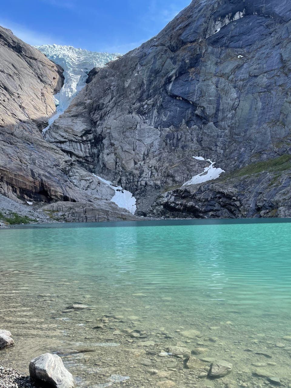 A shallow blue lagoon next to mountains at Briksdal Glacier - Leah Chen