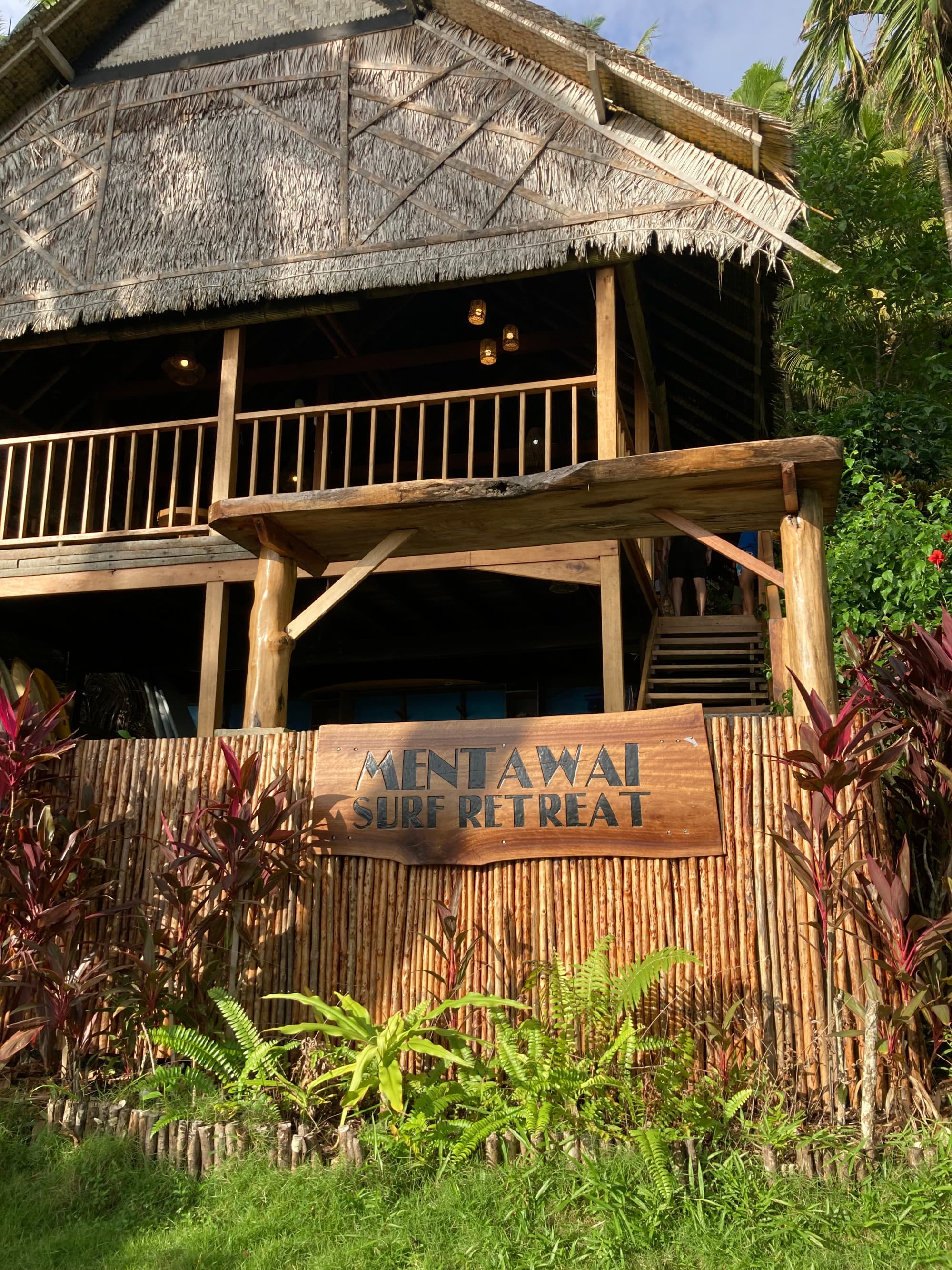 A picture of Mentawai Surf Retreat – a brown building with green grass and trees