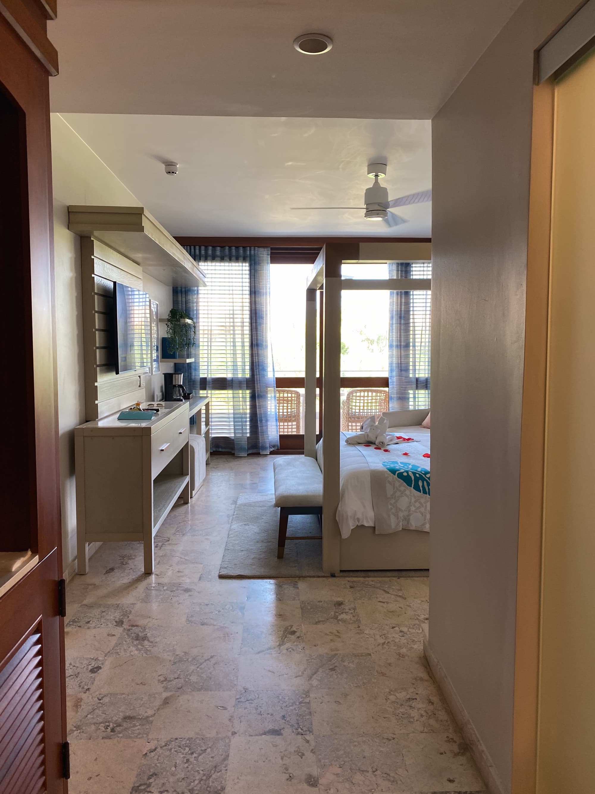Hotel room interior with a canopy bed and floor-to-ceiling windows.