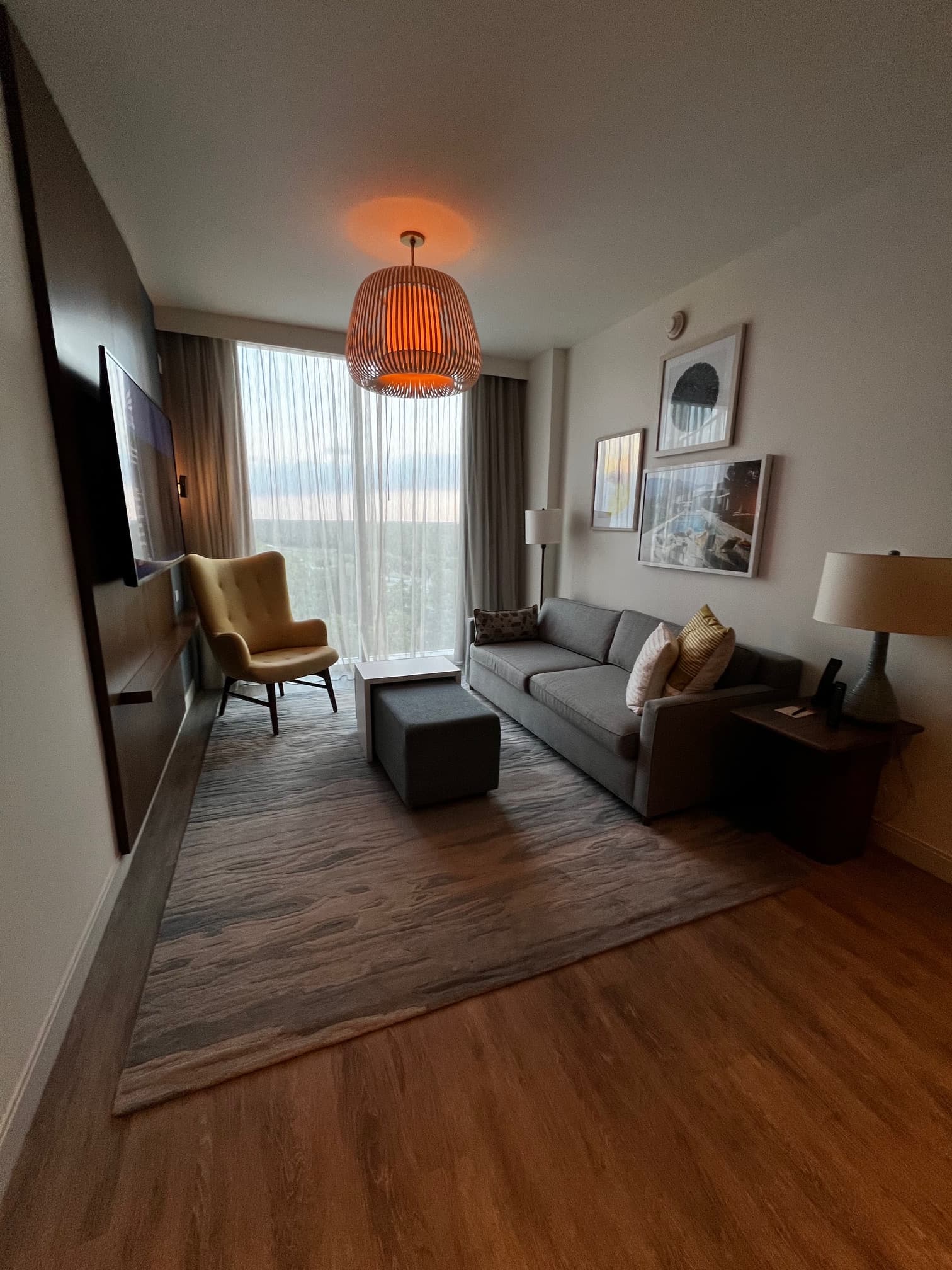Sitting area with wooden floors and a pendant light bulb.