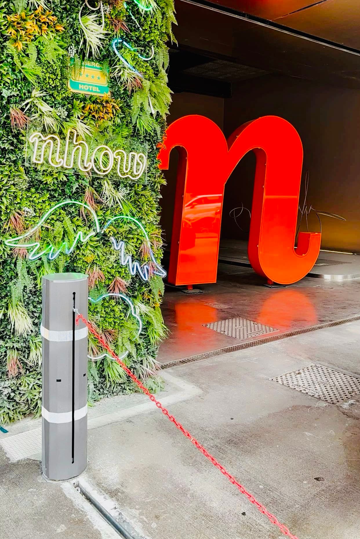Large red sculptural letter n outside of hotel entrance.