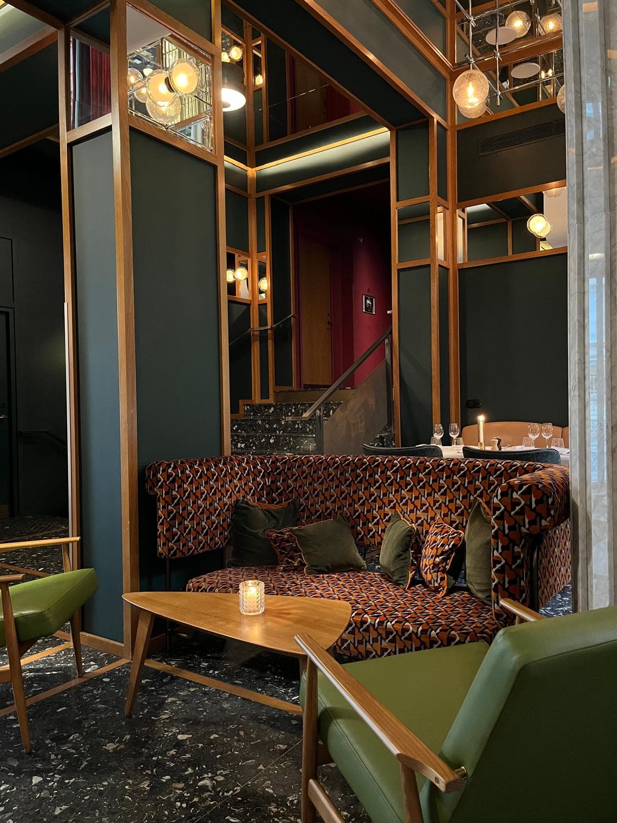 Hotel lobby with Midcentury chairs and a burgundy couch.