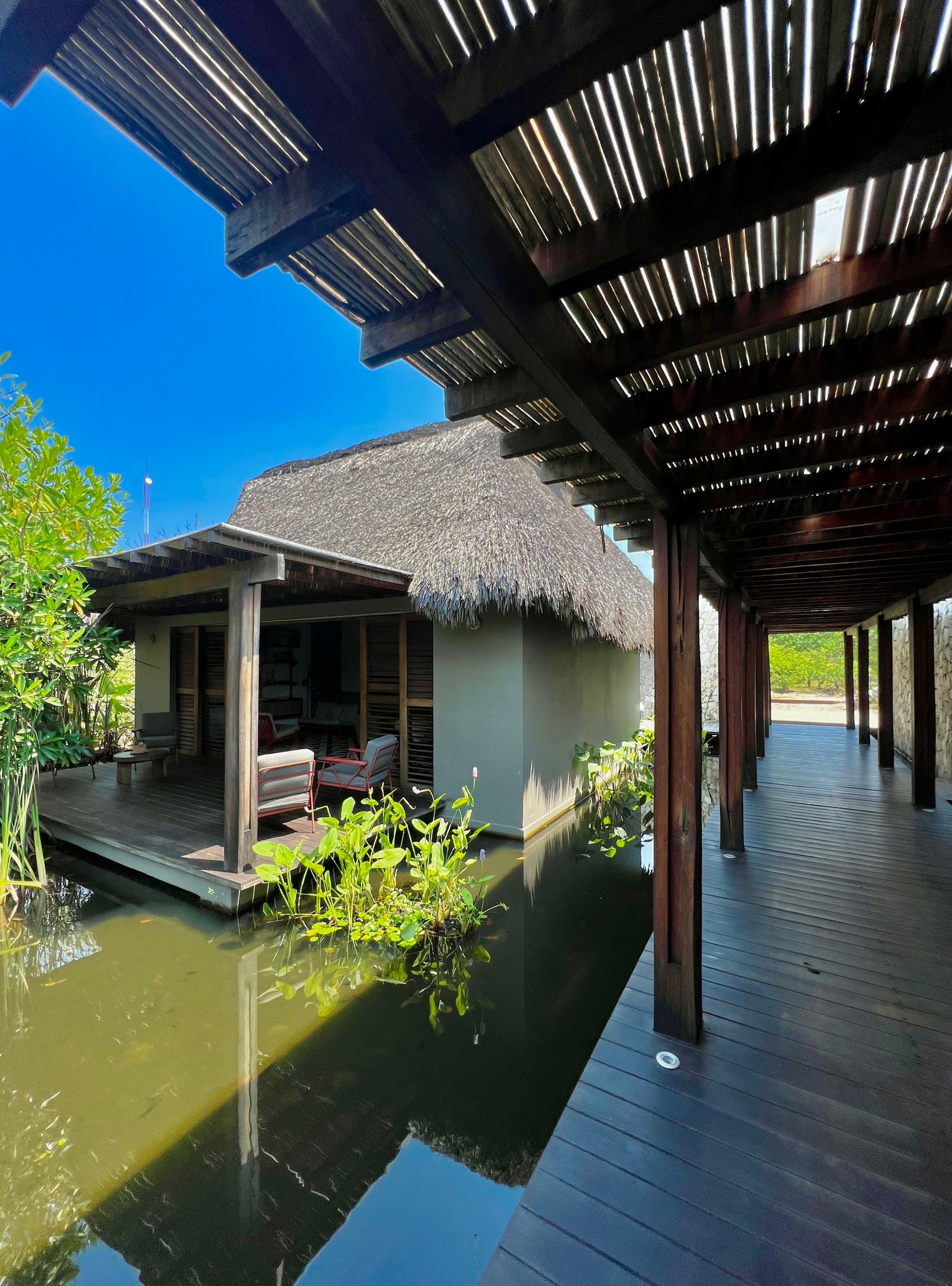 Hotel grounds with a koi pond and shade awnings.