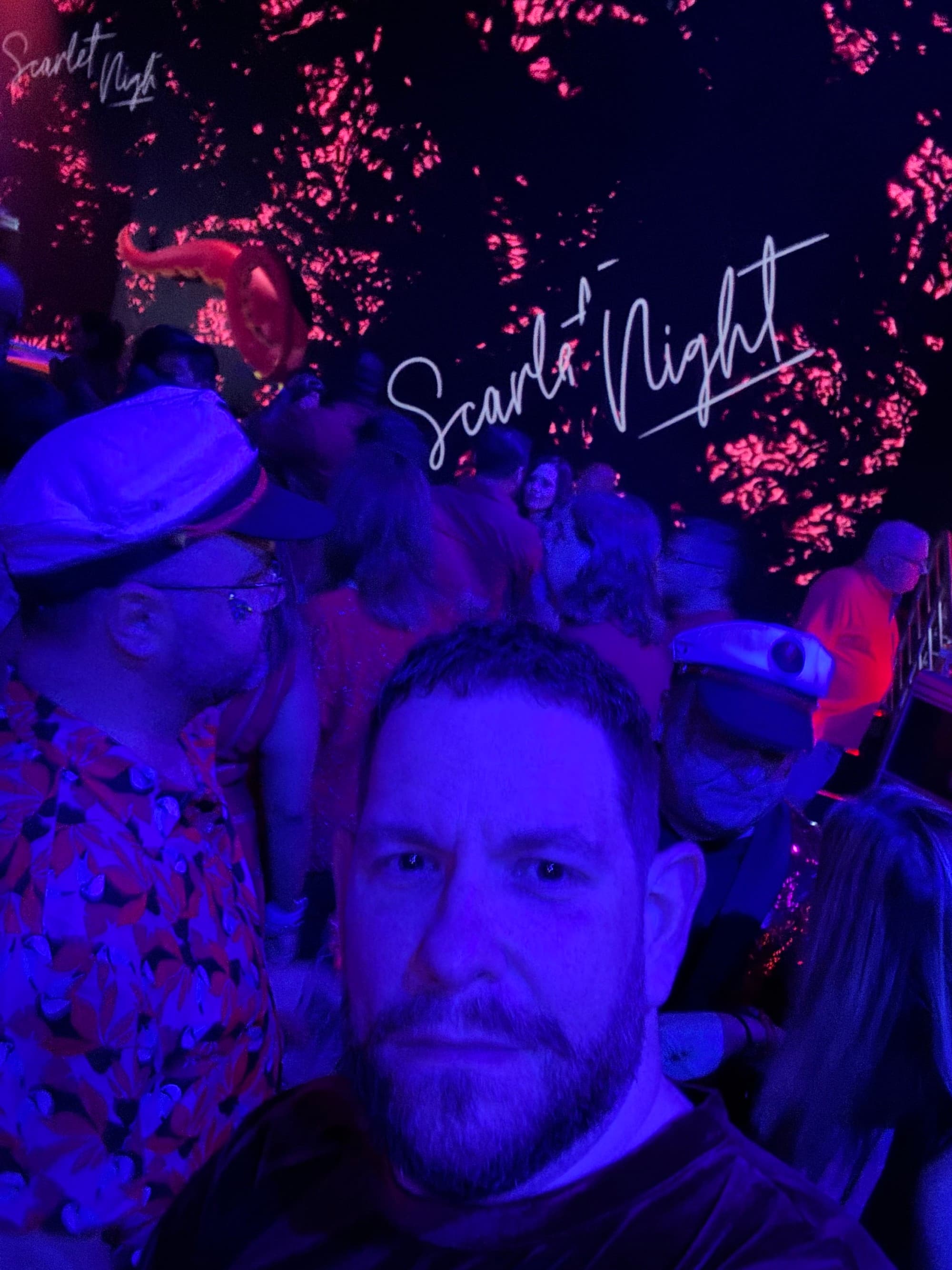 Selfie of the travel advisor under a black light at a party.