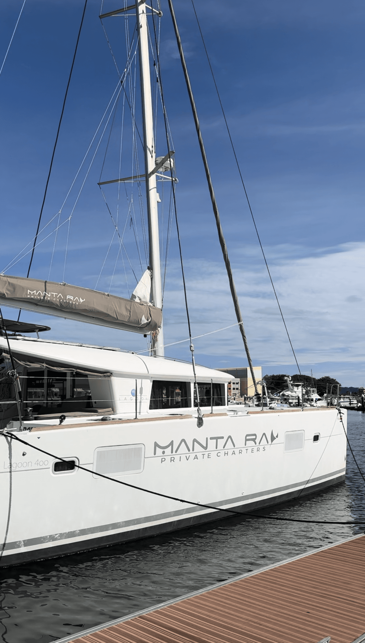 A catamaran docked just off the pier on a sunny day.