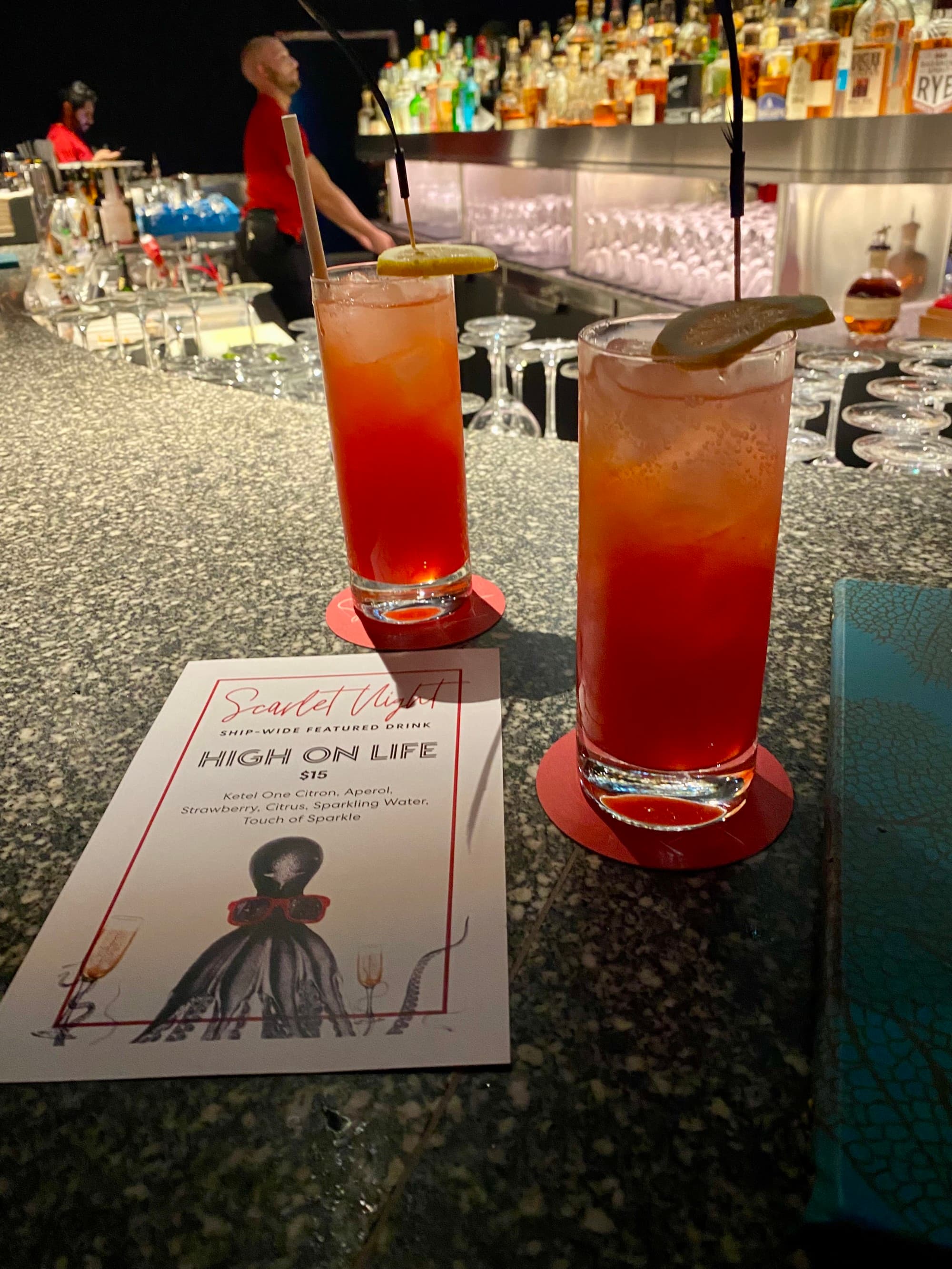 Two full cocktail glasses sitting on a bar