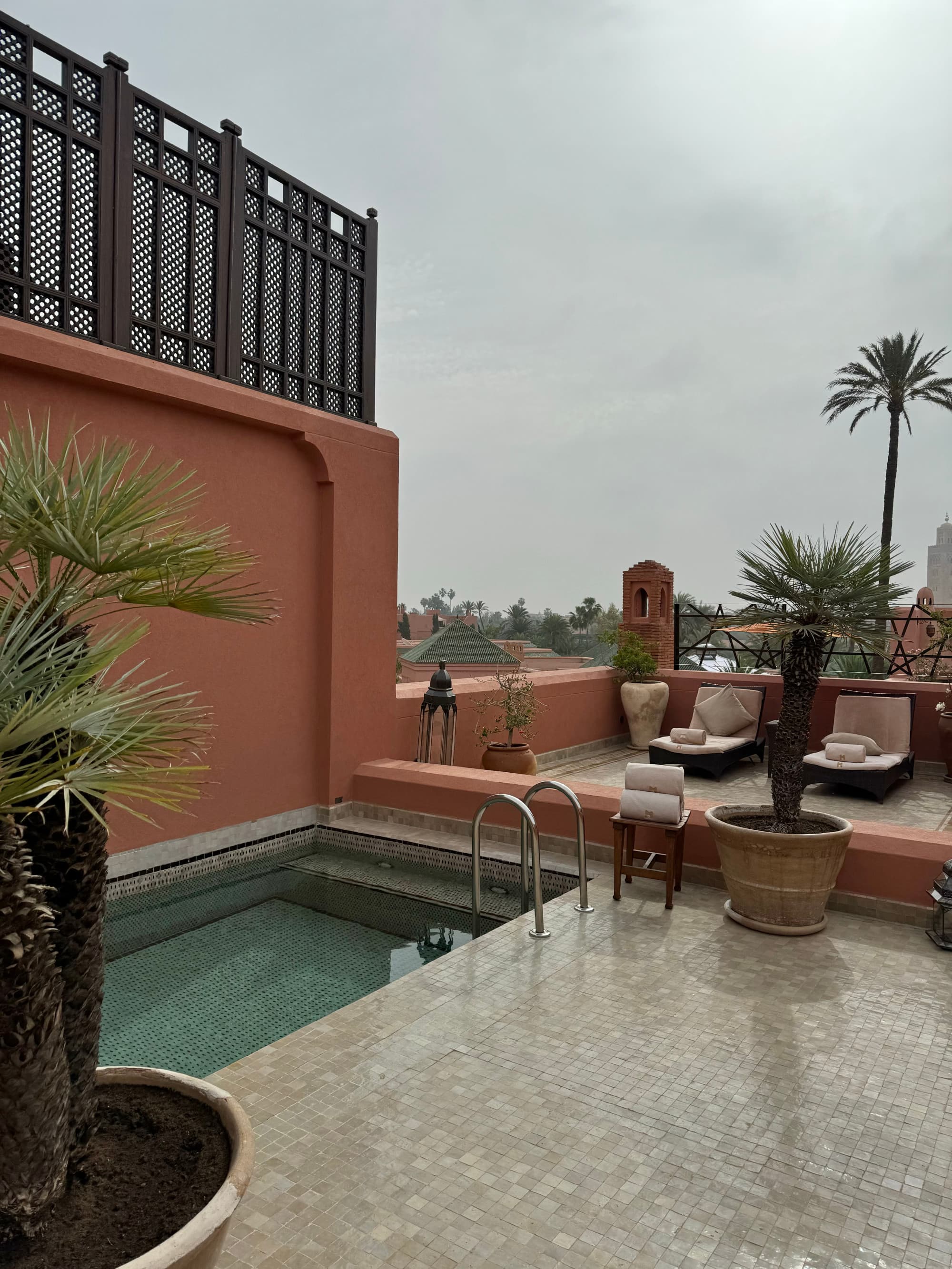 A rooftop area with a swimming pool during a cloudy day