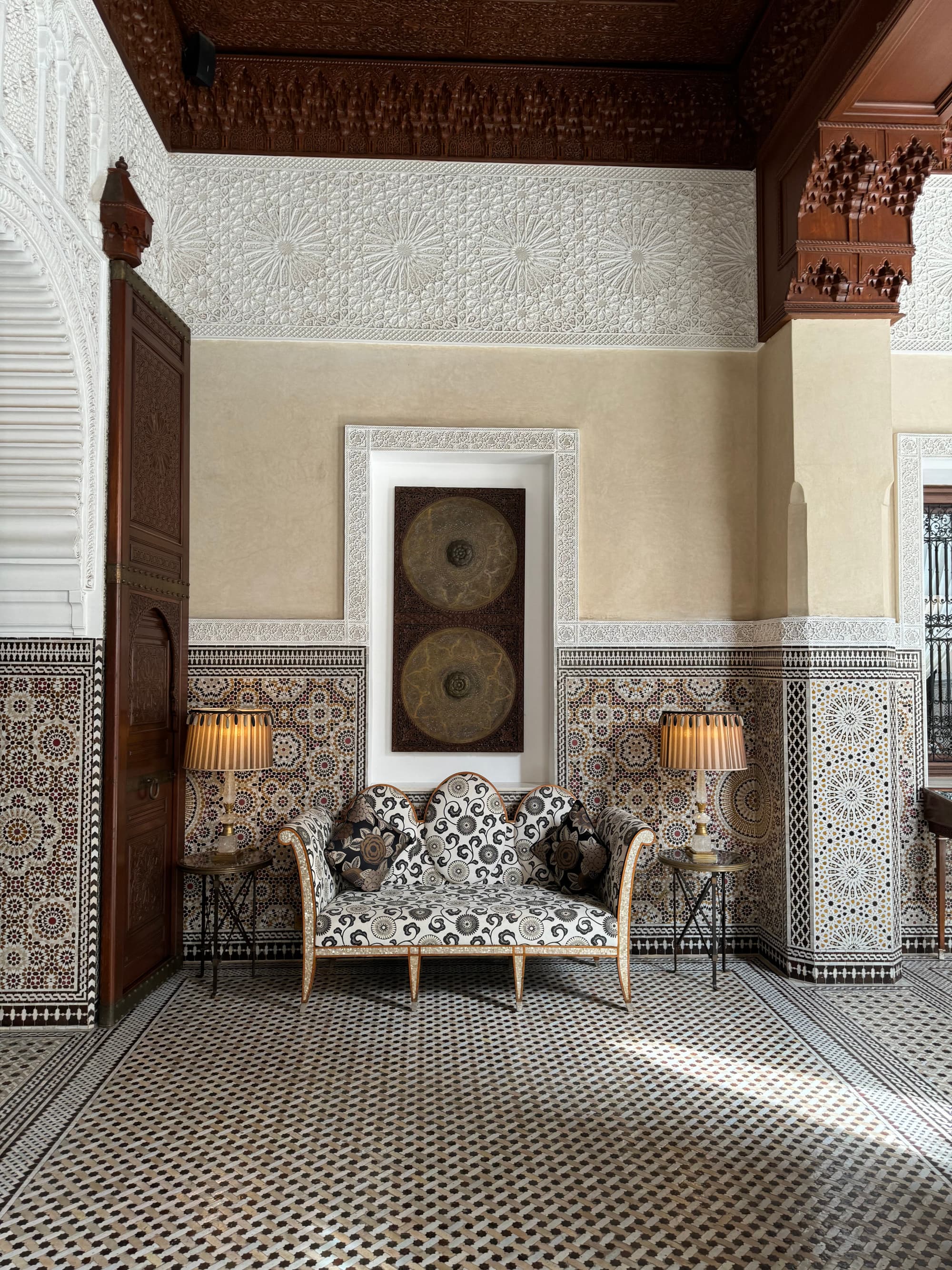 A hallway with decorated walls and a floral couch against the wall