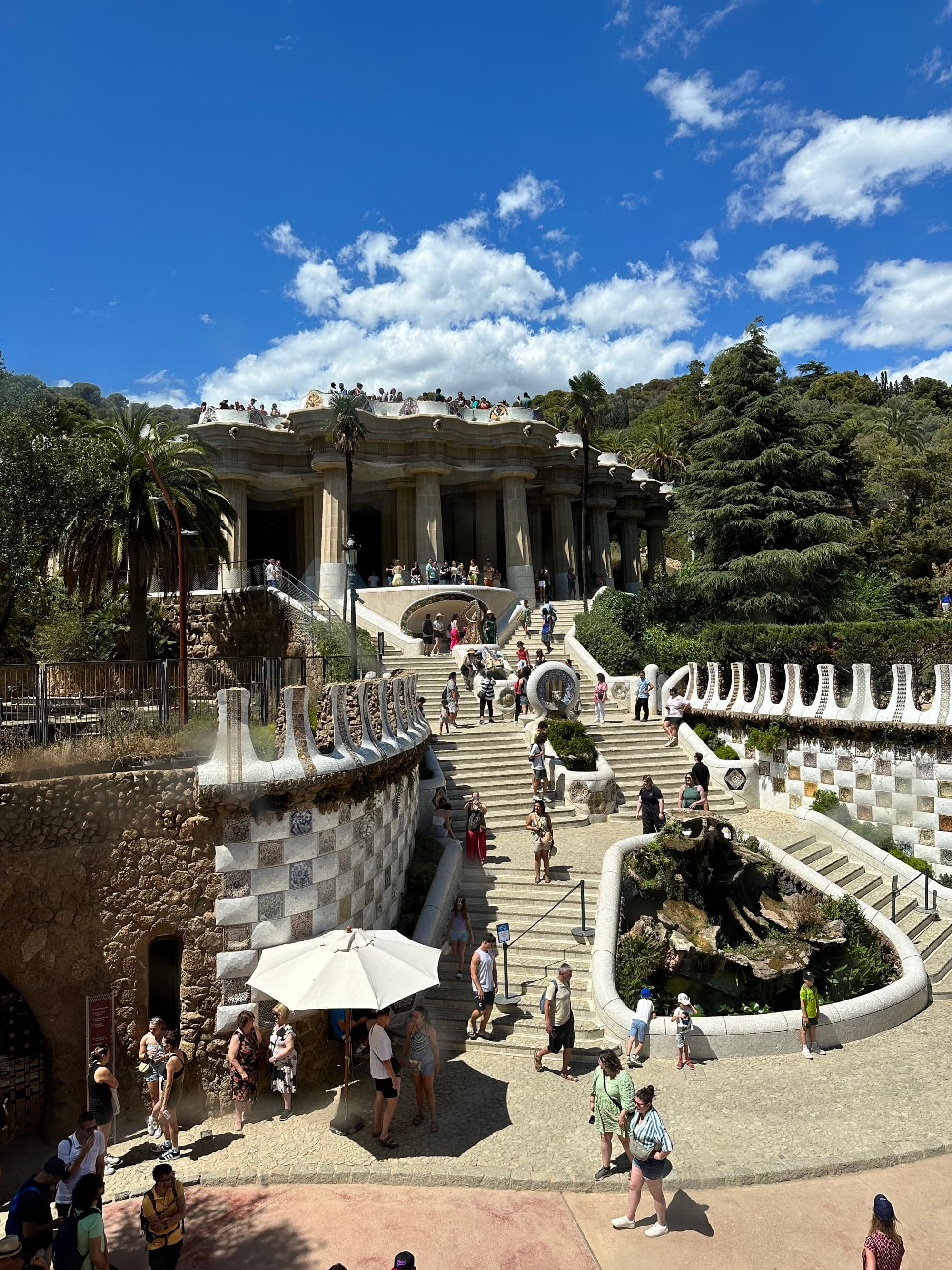 A large set of stairs in the middle of a park with numerous people walking around
