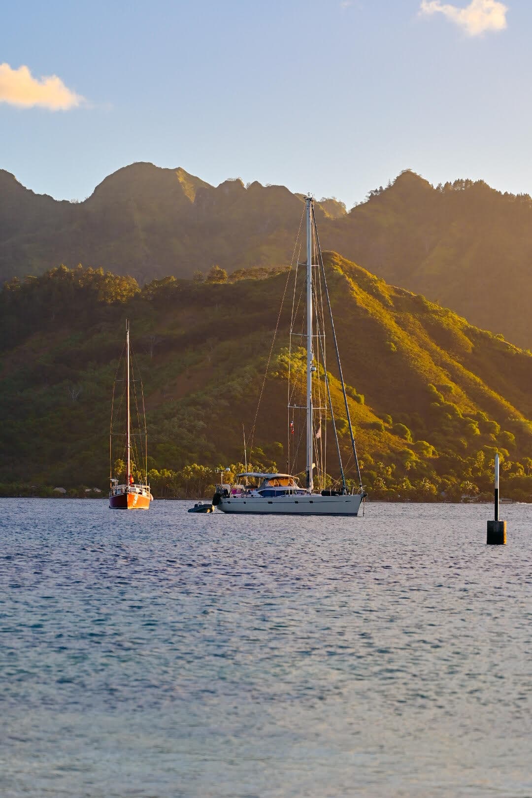 Sea boats on the water below mountains.