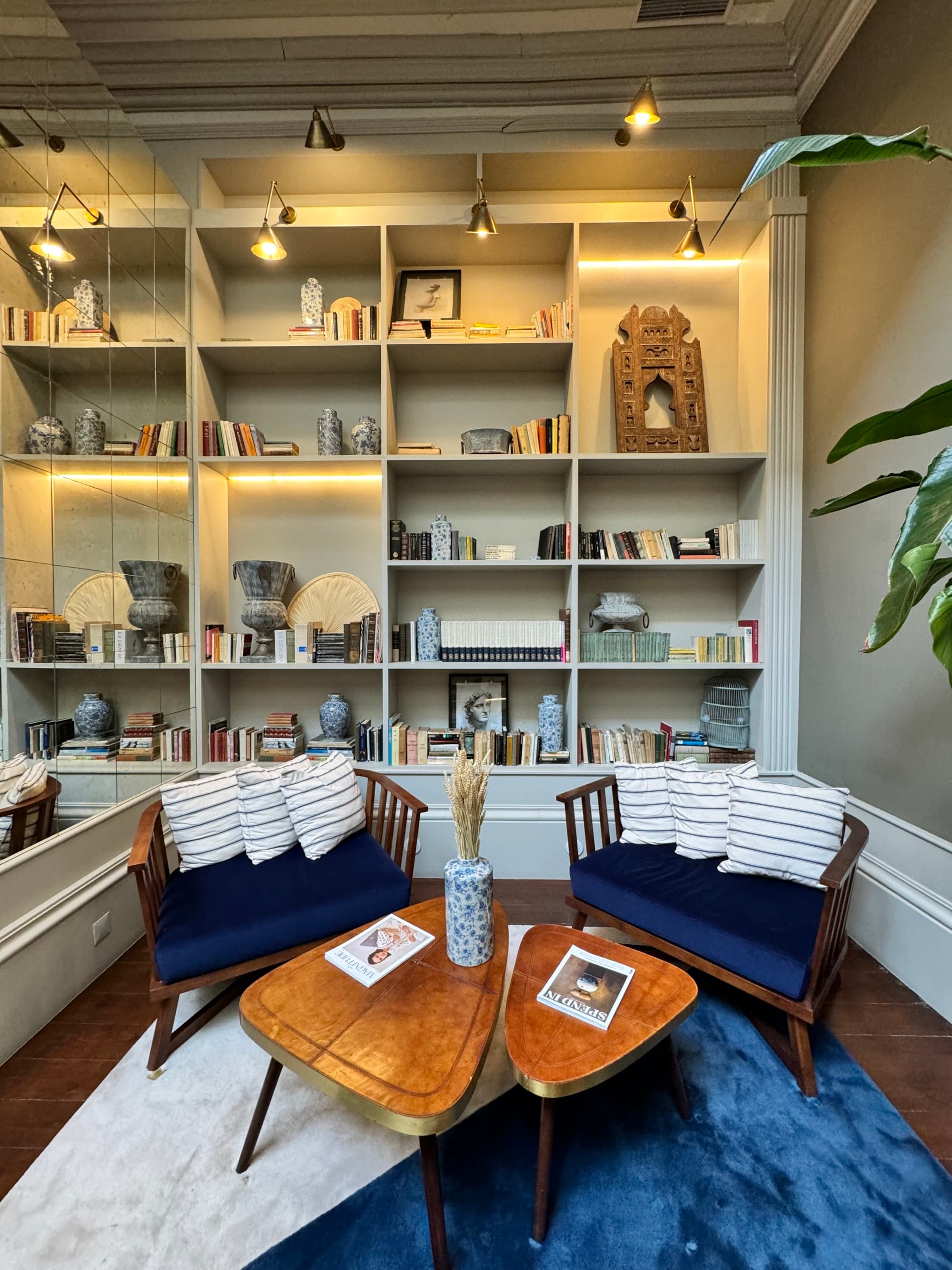A library with blue chairs on front of book cases