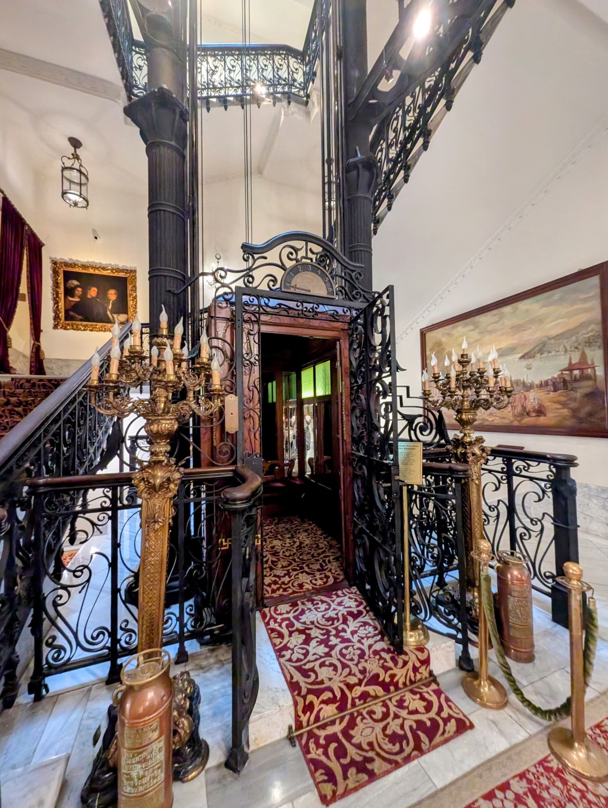 An old-fashioned elevator with a wrought iron door.