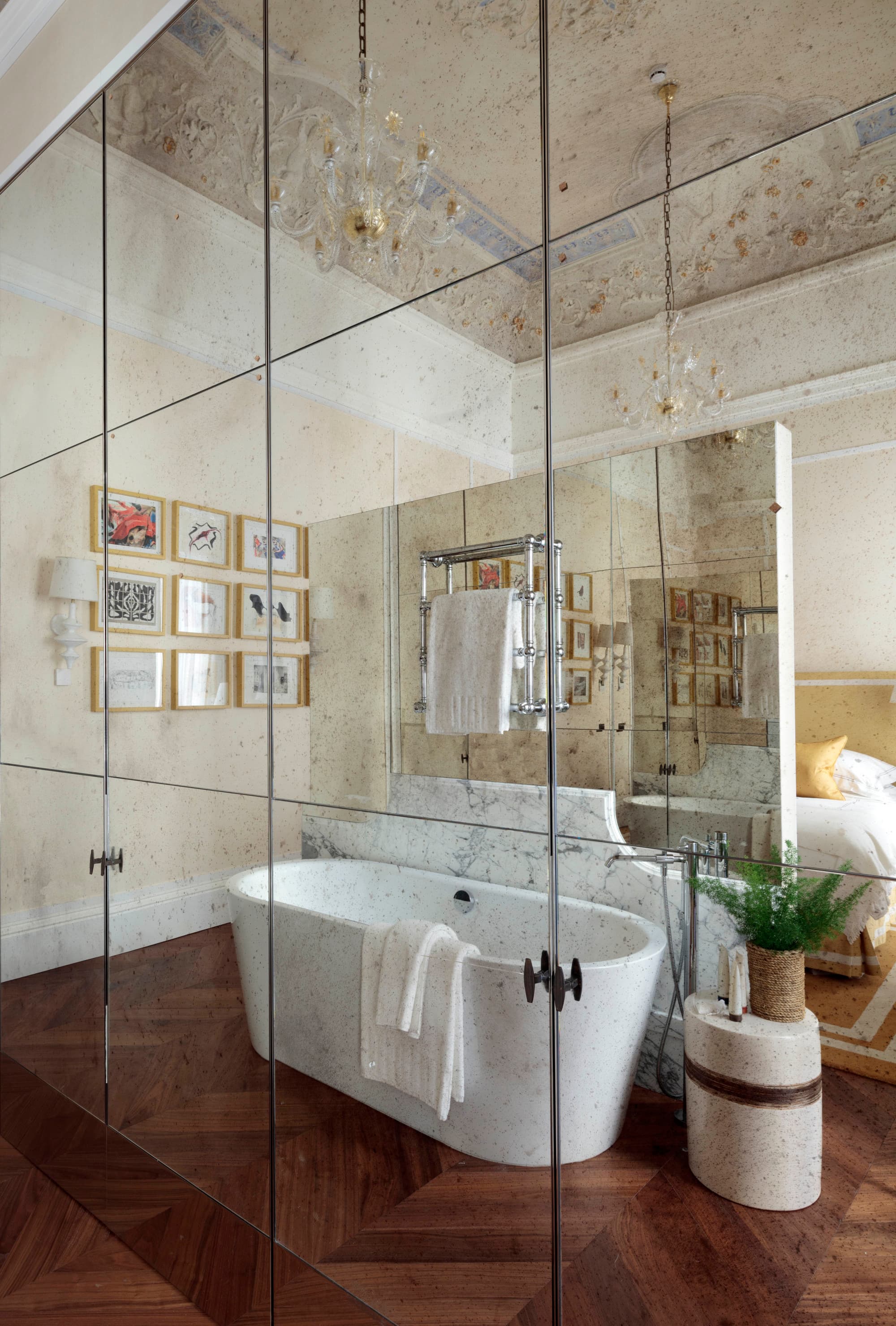 a glass-walled bathroom with a deep soaking tub