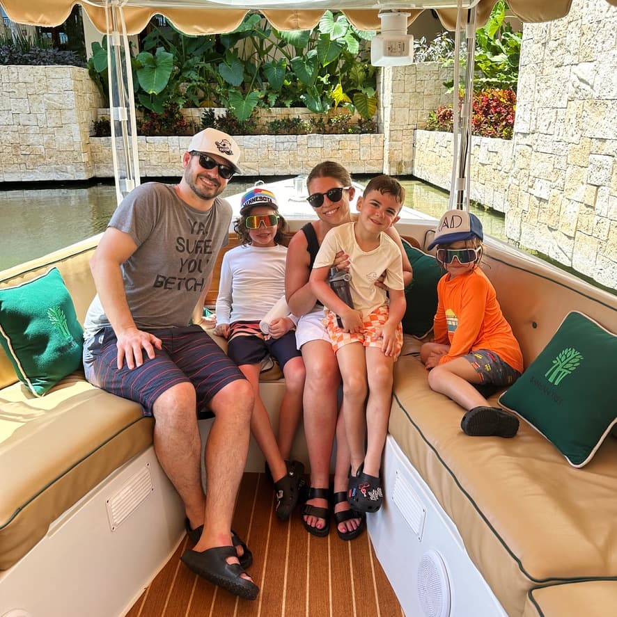 A family posed for a photo on the bench seats on a small boat.