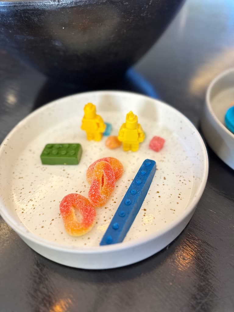 A dish with small toys including some Legos.