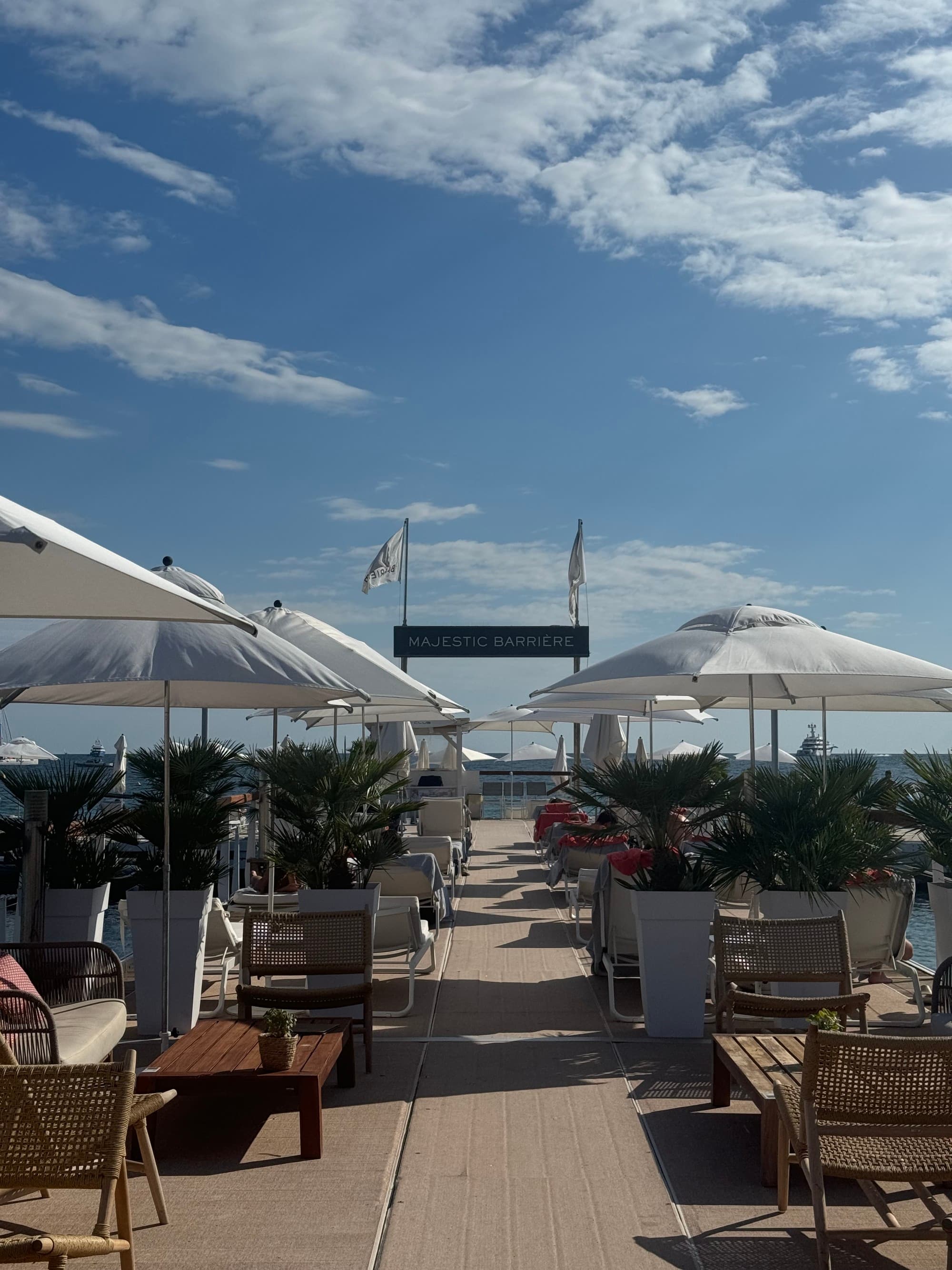 View of the pool surrounded by loungers and umbrellas on a sunny day.