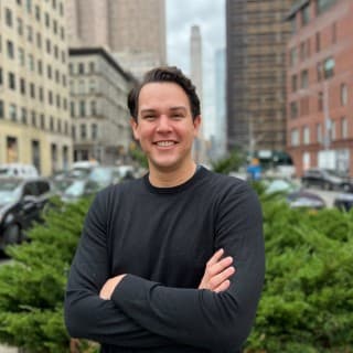 Fora Head of Training Ross smiling in black shirt with arms crossed.