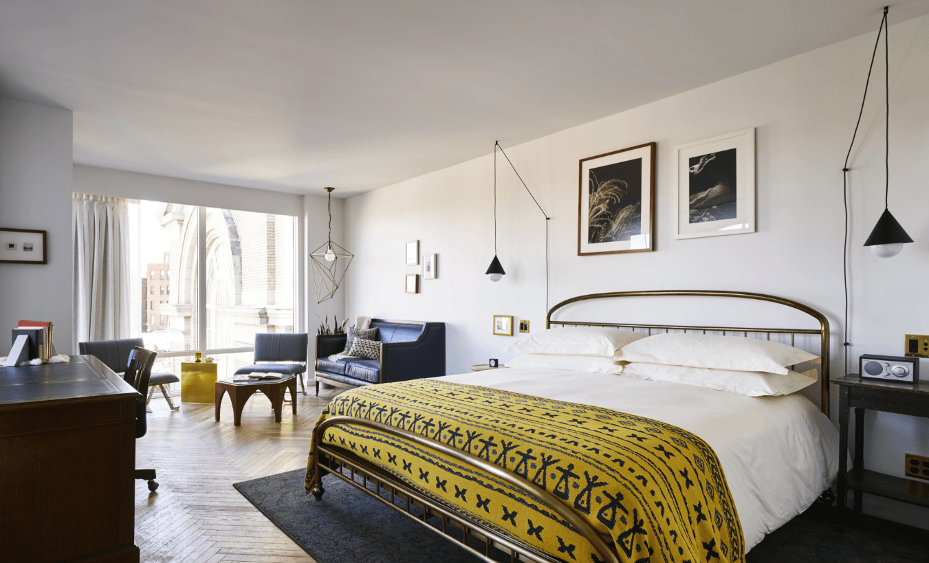 A hotel bedroom with a eclectic, vintage style and furniture.