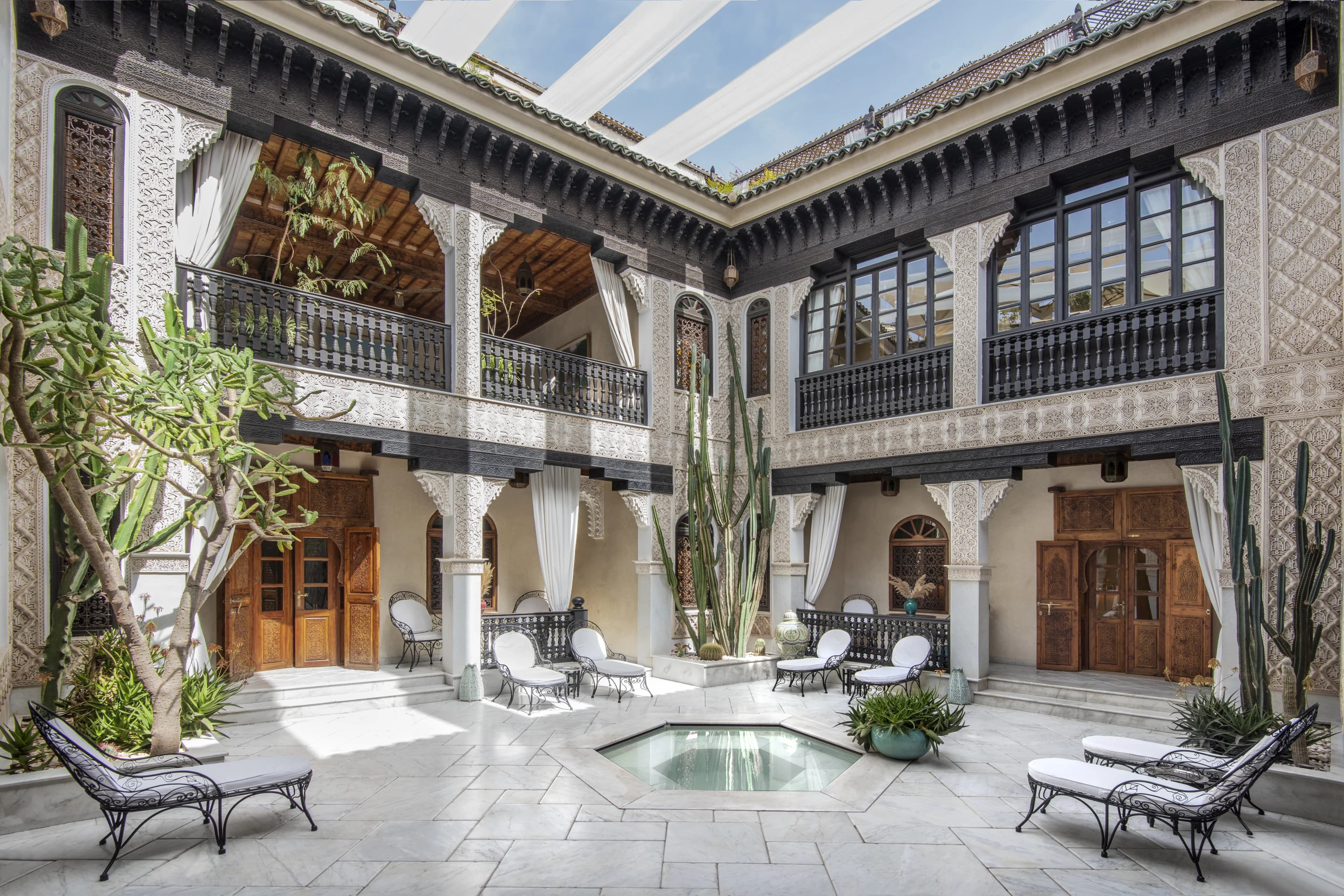 an ornate Moroccan courtyard with white tiered archways