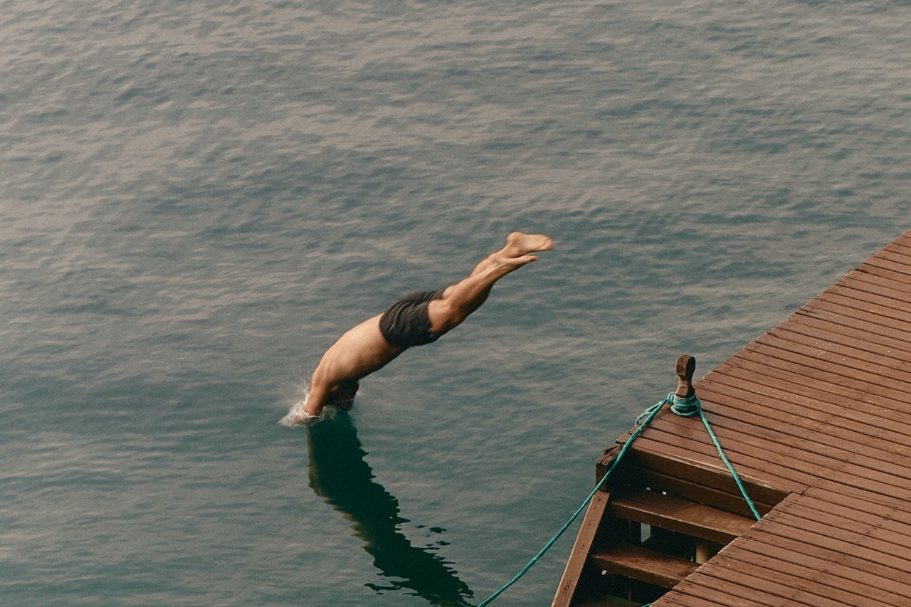 a man dives into a body of water