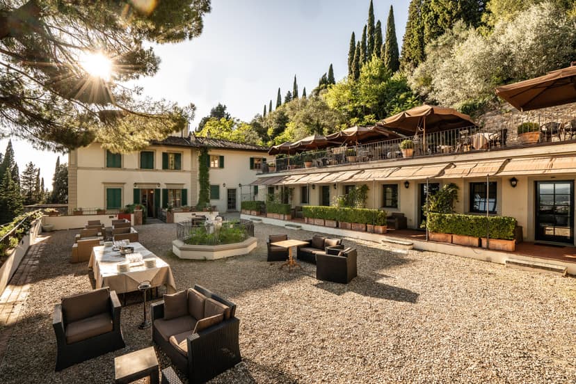 An outdoor courtyard area at Villa Fiesole with seating area and beautiful gardens.