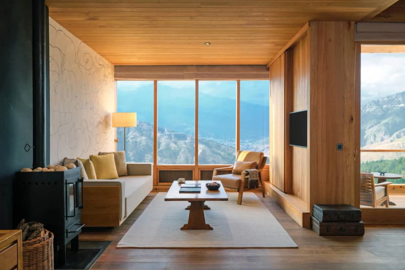 a sleek hotel room with pale wood overlooking an alpine valley