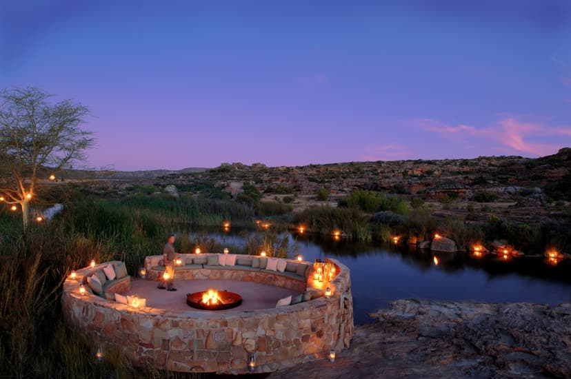 outdoor stone seating area illuminated by lanterns