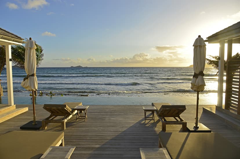 two chairs on a wooden deck overlooking the sea