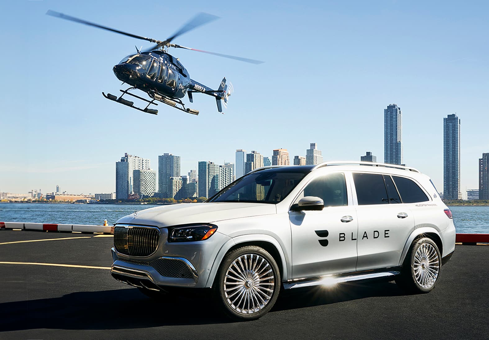 A BLADE car on a tarmac with a helicopter above in New York.