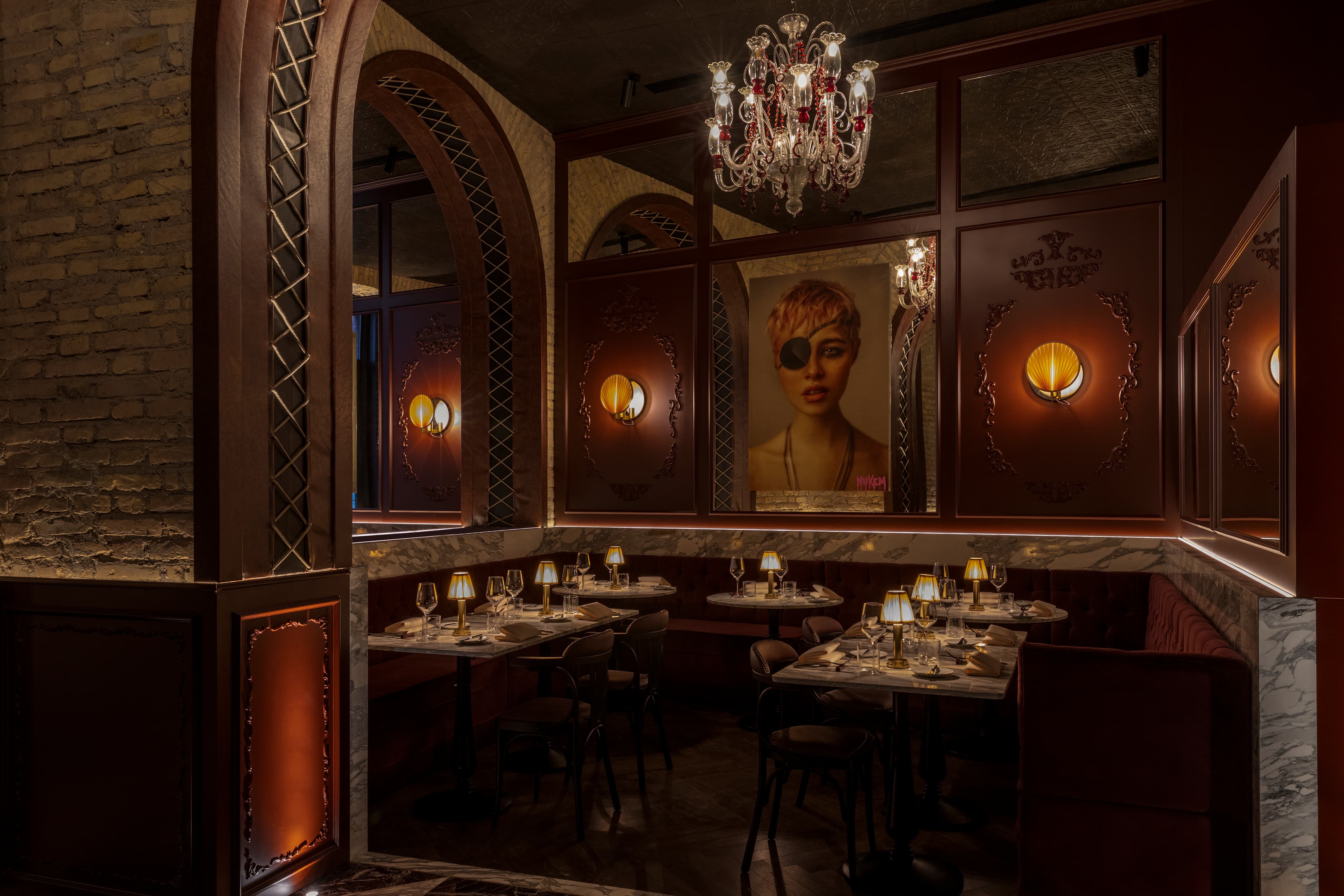A wood-paneled restaurant with an intricate chandelier and a painting of a woman with an eye patch on the wall.