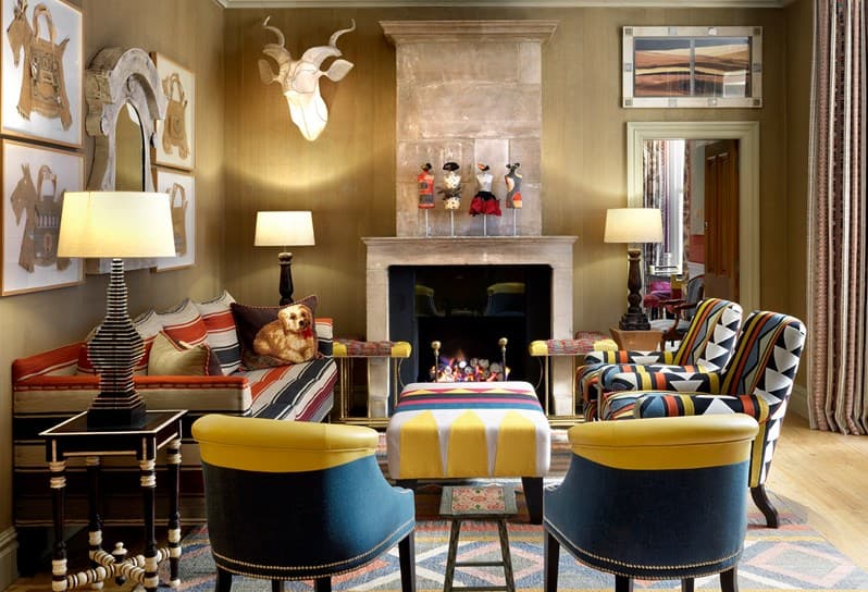 a colorful living room with a fireplace and brightly patterned chairs