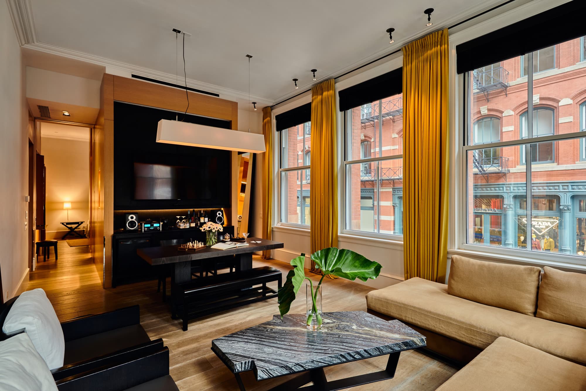 a large loft with yellow drapes and a black vanity