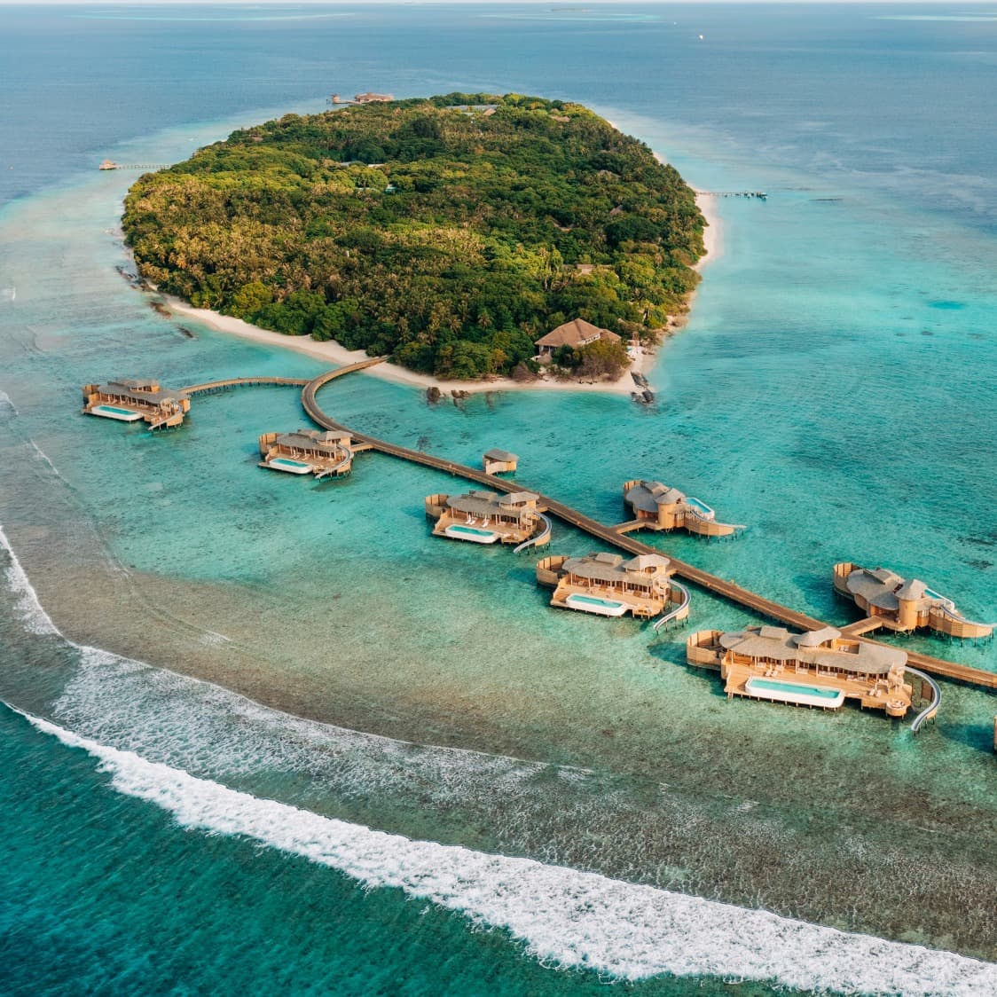 aerial view of overwater bungalows in a turquoise sea
