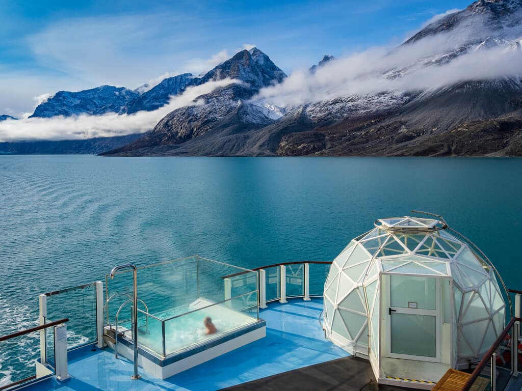 an octagonal tent near a hot tub on a ship deck