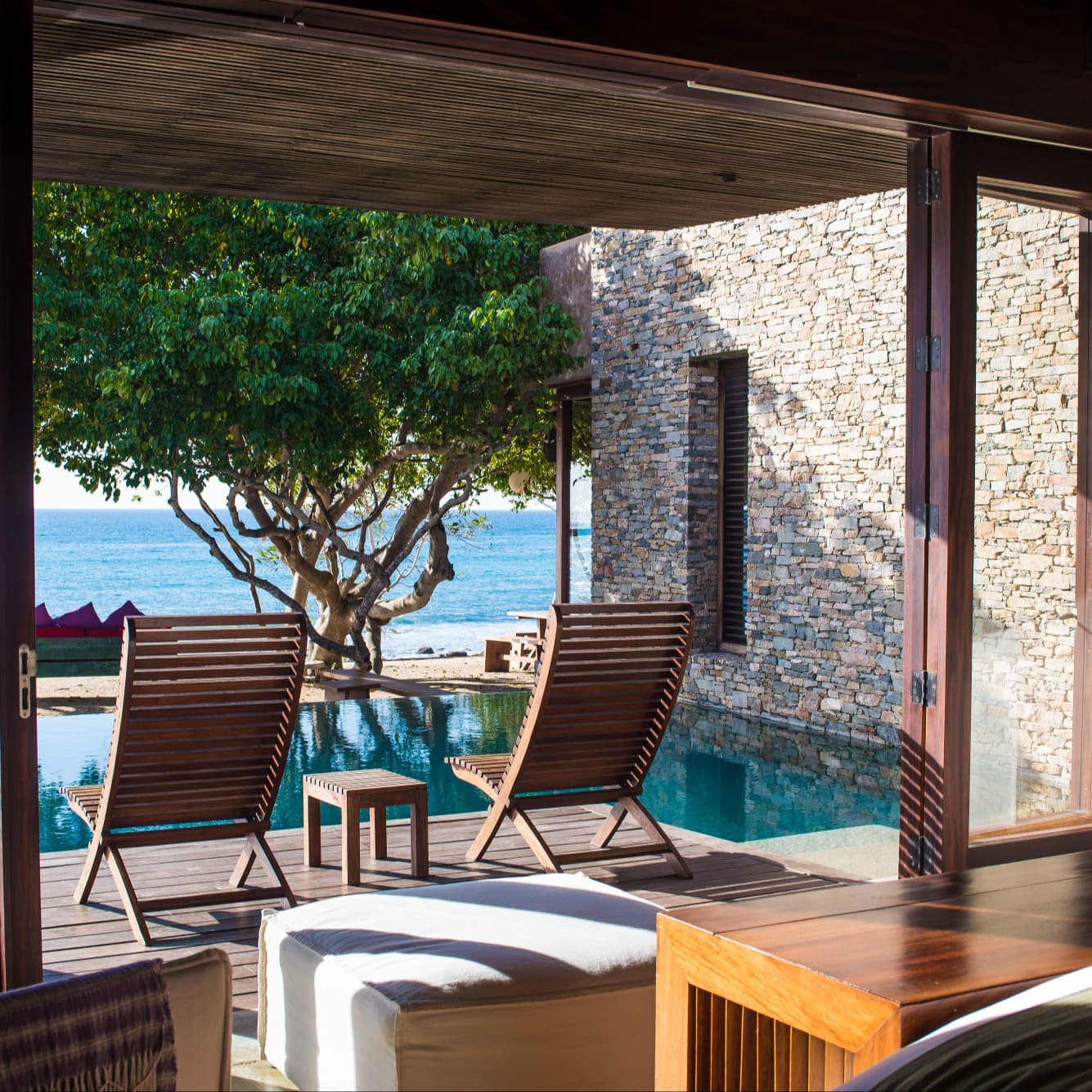 a bedroom with a terrace overlooking a private plunge pool and the sea