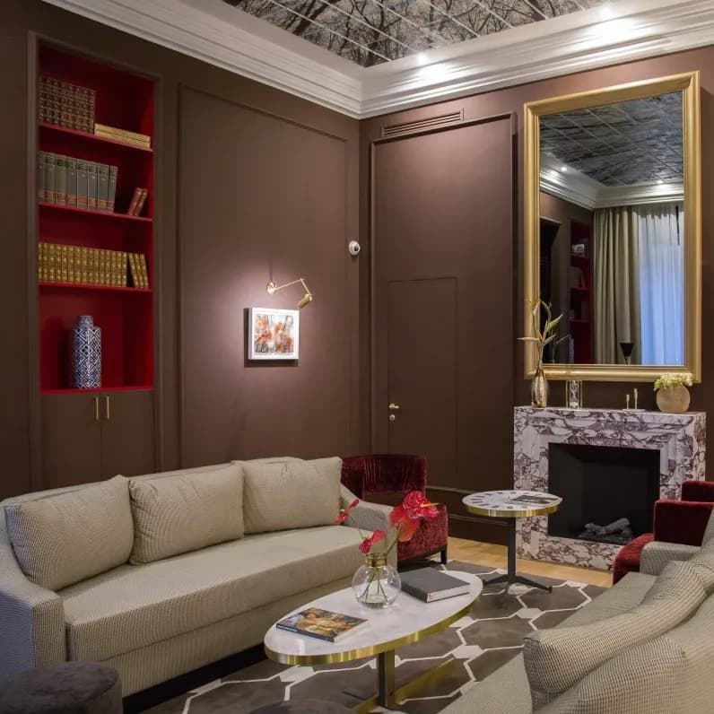 dimly lit living room with eggplant-covered walls and a red bookshelf