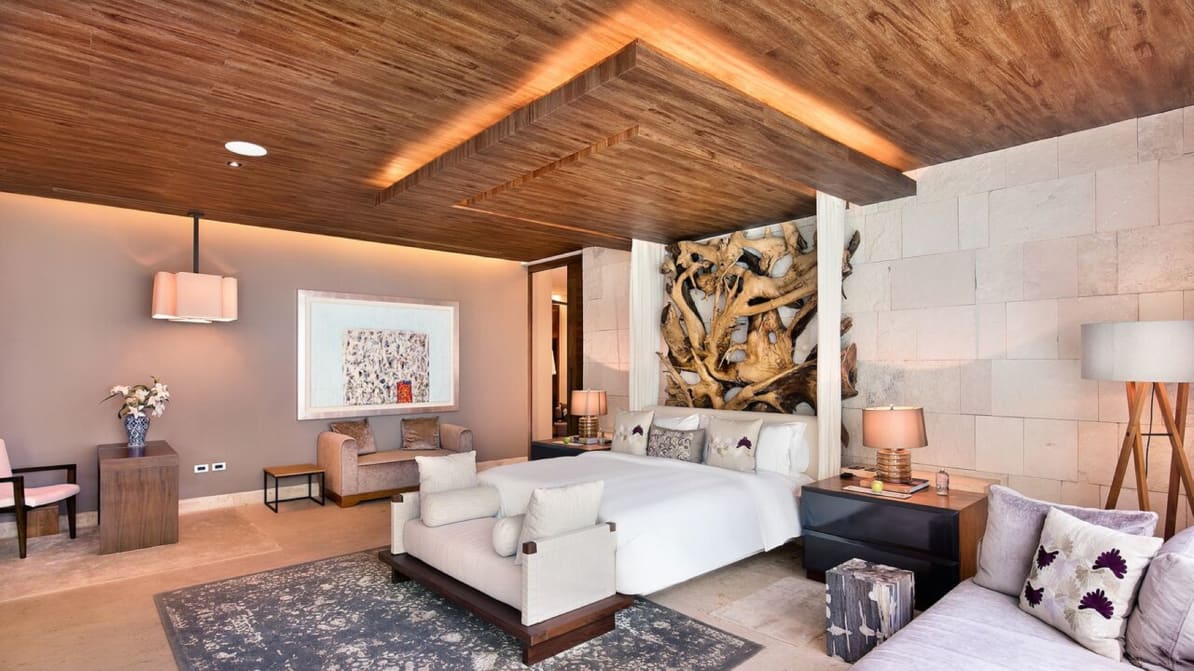 white bed in front of a wooden piece of art