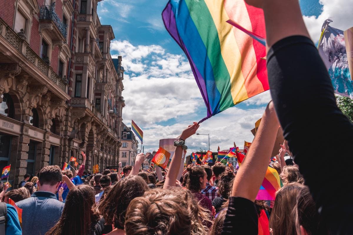 Pride flag waving at LGBTQ+ celebration in city on a sunny day