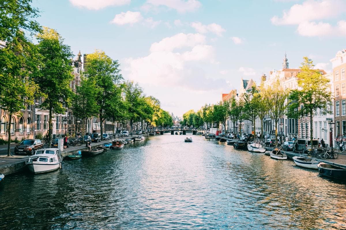dutch canal flanked by townhomes and trees