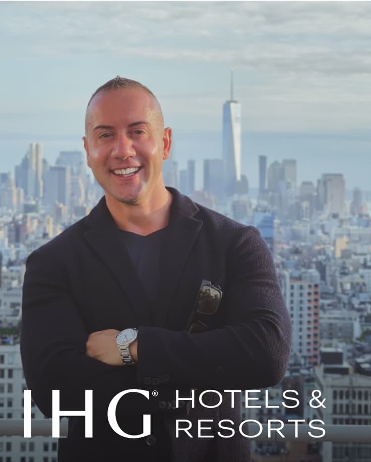 man in a black sweater standing on a balcony