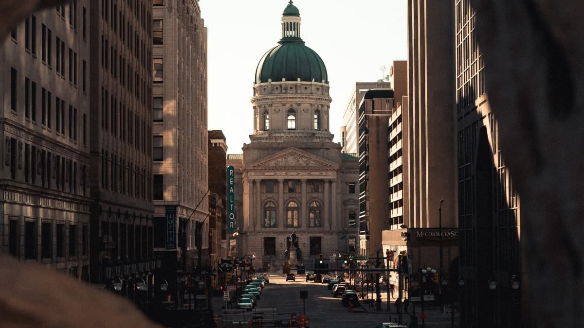 View of large white building between city streets.