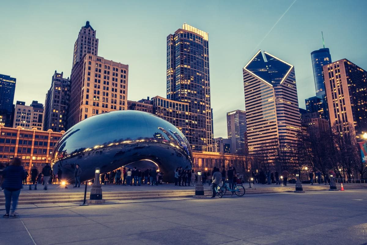 Downtown Chicago from the street at night with the Bean reflecting the lights.