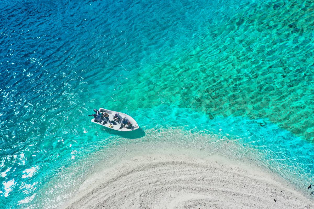 Boat on crystal clear turquoise water in the Caribbean Island of St. Martin on a sunny day.