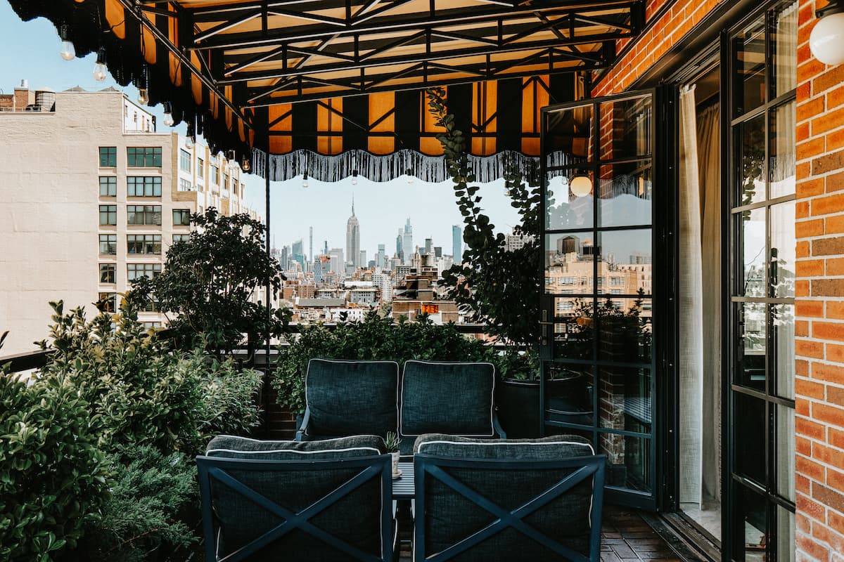 plush couches on an outdoor terrace overlooking a big city