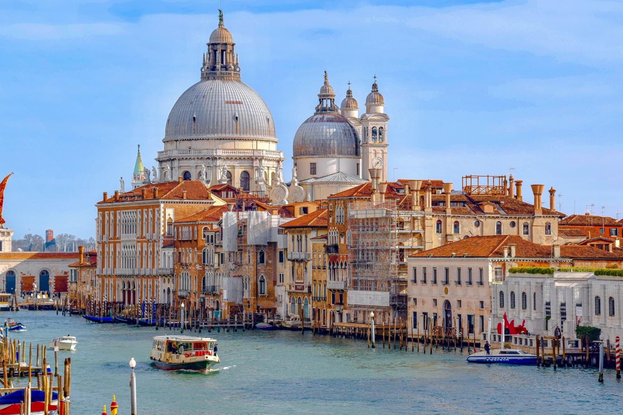 A ferry traverses Venice's Grand Canal with the city's famous cathedral in the background